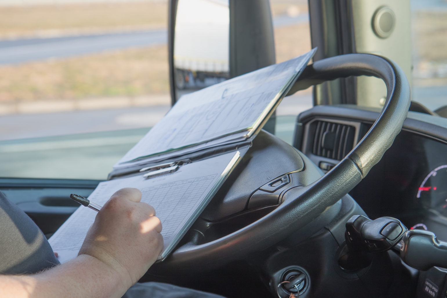 Driver writing on driving log book