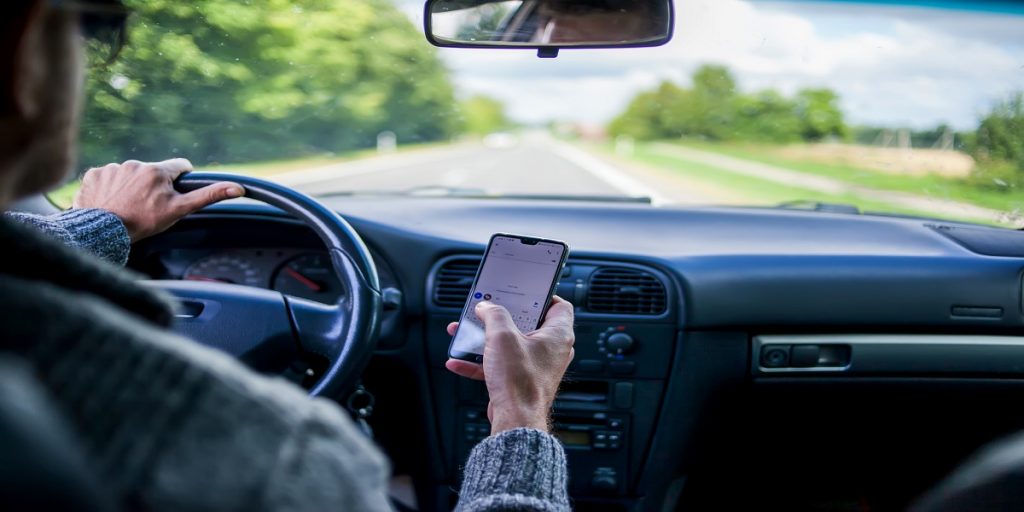 Aman using phone while driving car